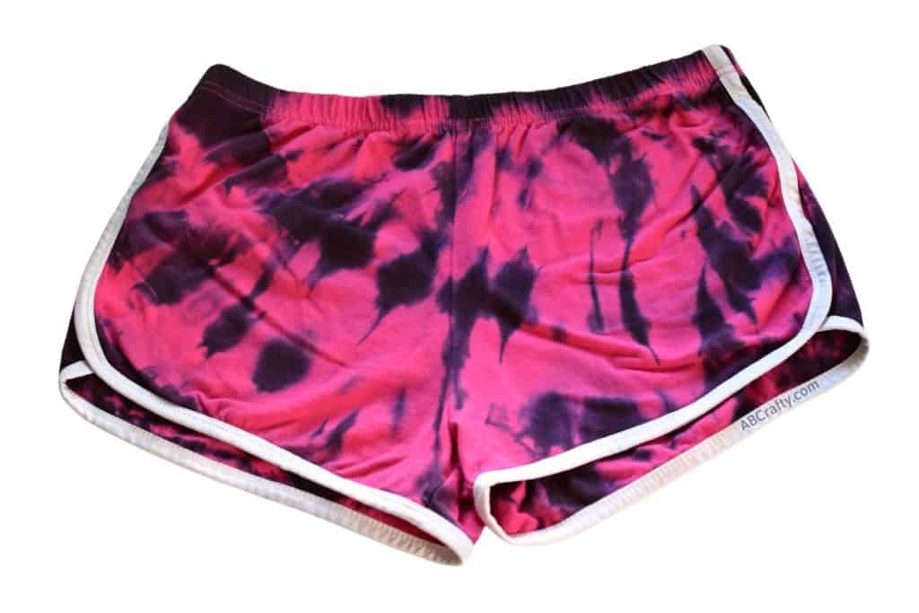 finished pink shorts with black tie dye in the shape of a spiral from the top corner