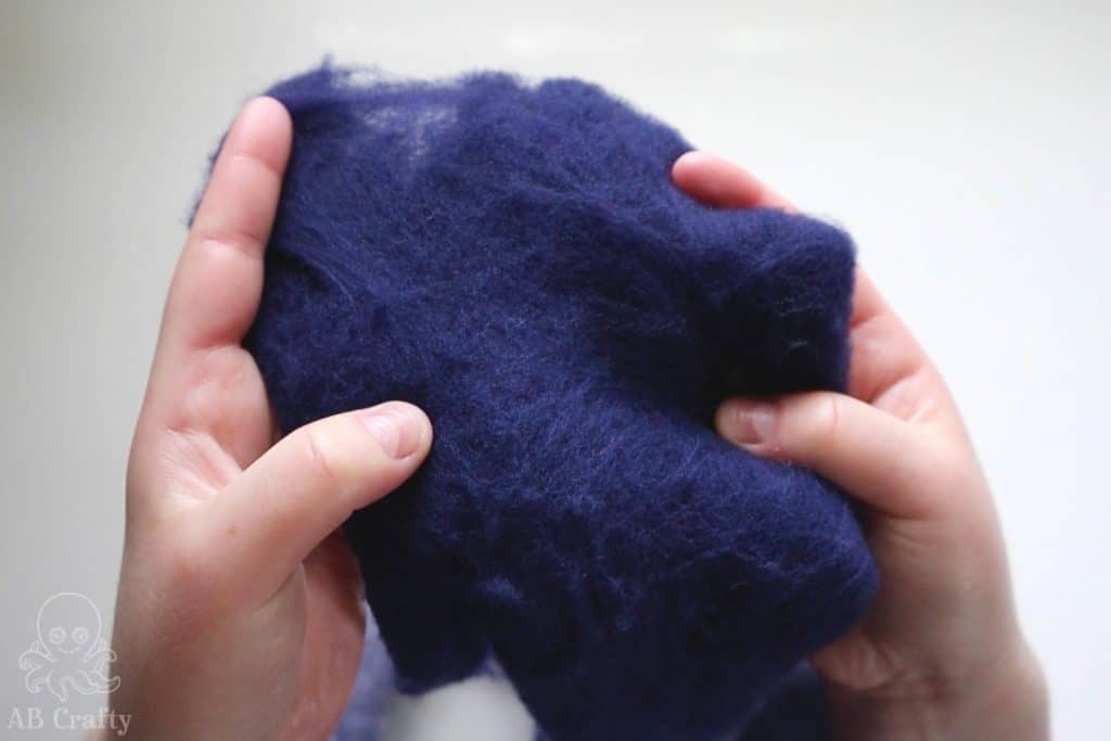 holding partially felted wool dyed in dharma dark navy