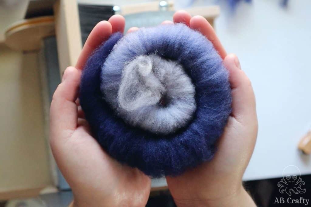 holding a navy blue finished rolag