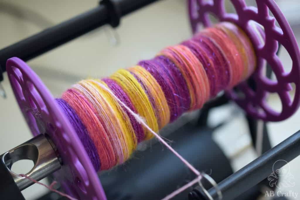 pink, yellow, and purple hand spun yarn spun into a single on an EWW6 electric spinning wheel