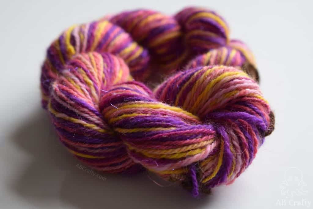 yellow, purple, and pink hand spun yarn with pink angelina fiber