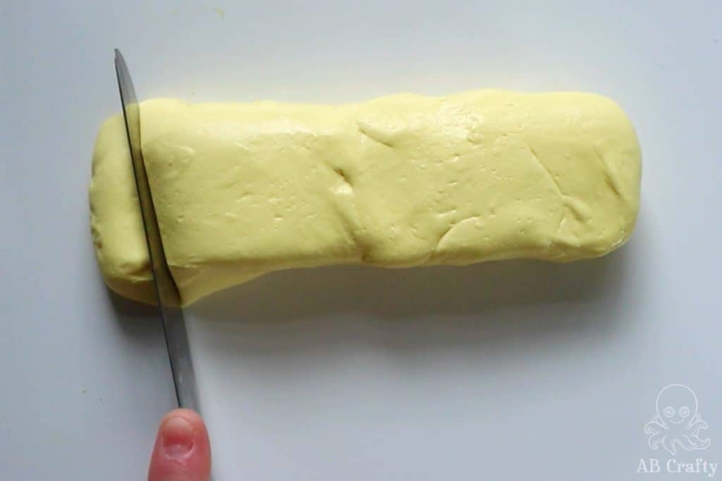 using a knife to cut a pad of "butter" off the end of the butter slime shaped into a stick of butter