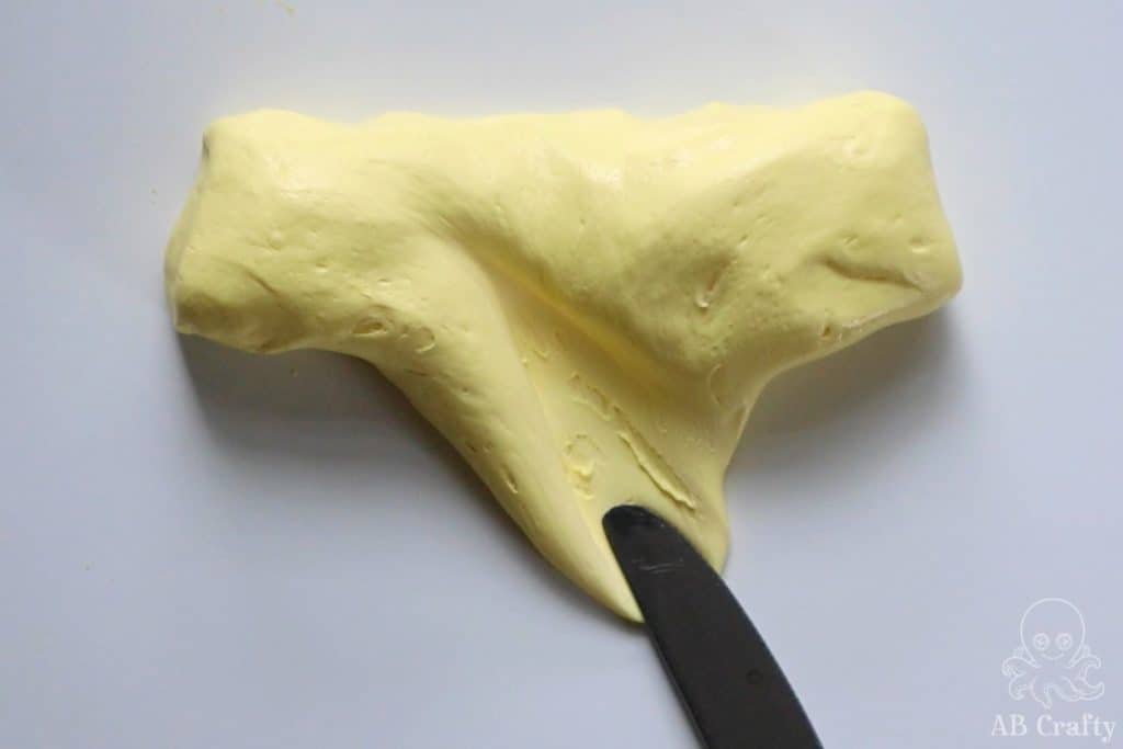 using a knife to spread the yellow butter slime that has been shaped into a stick of butter