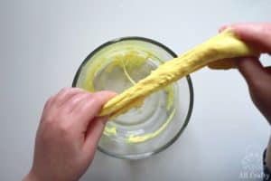 lifting yellow glue and activator out of a bowl and stretching it