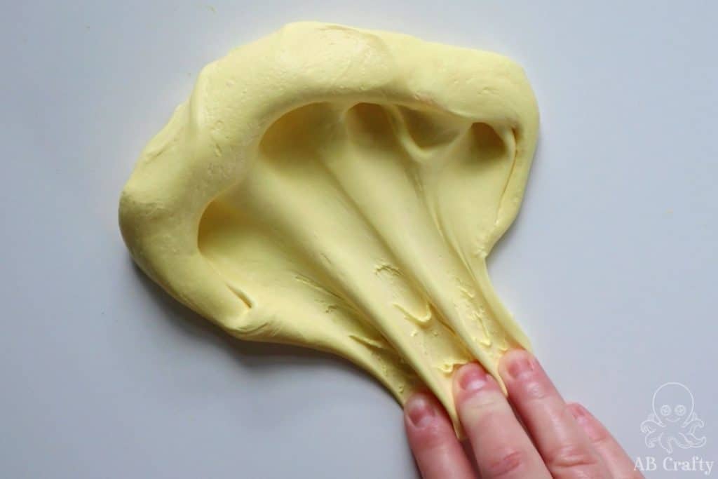 pulling fingers through the yellow butter slime to spread it
