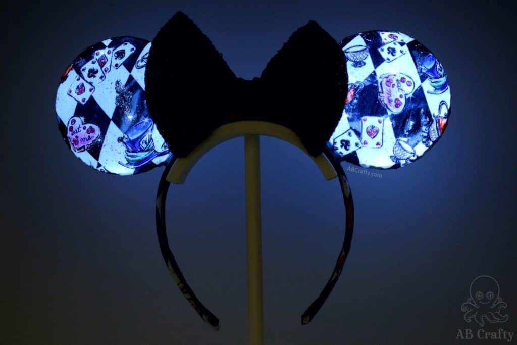 finished light up alice and wonderland disney ears with black sequin bow and checkerboard alice in wonderland fabric, glowing in the dark