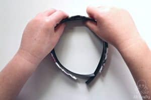 attaching the black satin ribbon to the inside of the headband