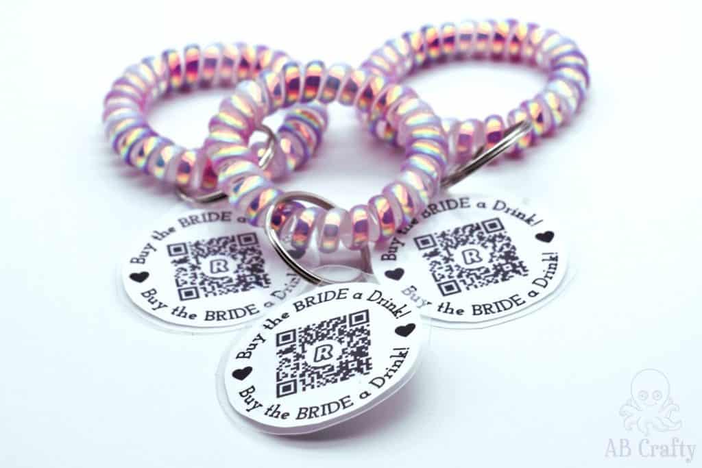 3 finished pink bachelorette venmo bracelets with a qr code that say "buy the bride a drink" venmo