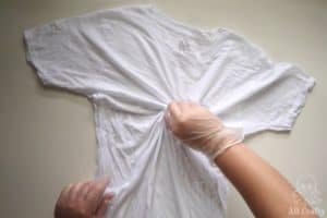 twisting a wet white cotton shirt from the middle