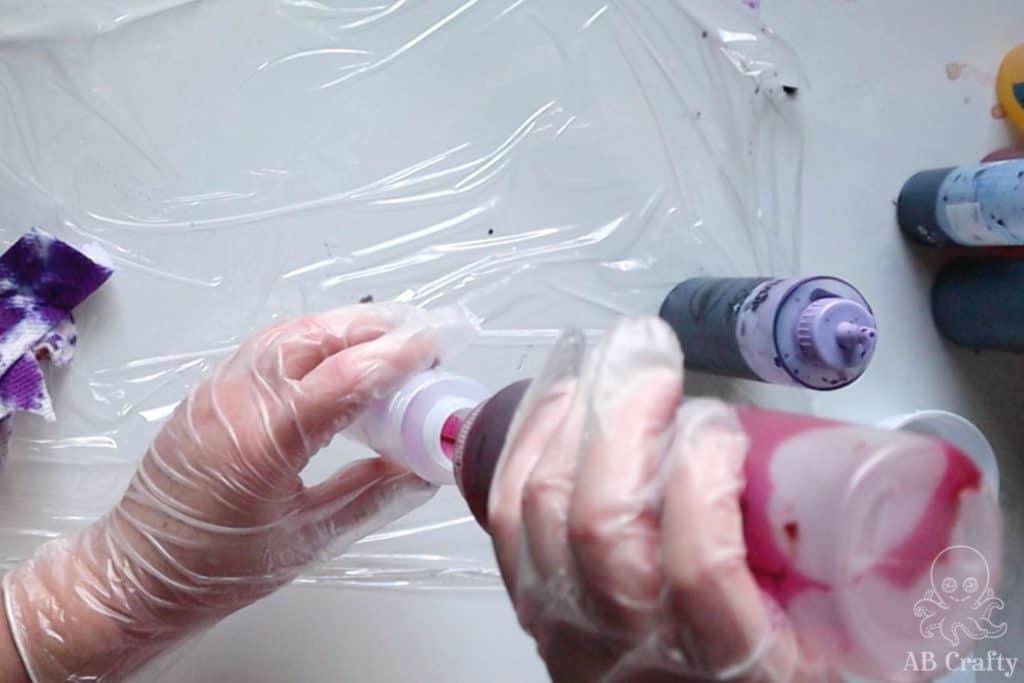 adding pink tie dye dye to an empty squeeze bottle