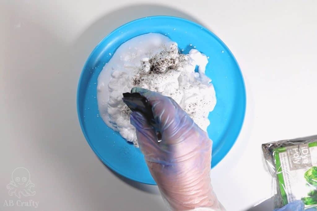 sprinkling powdered dye on top of shaving cream in a plastic frisbee