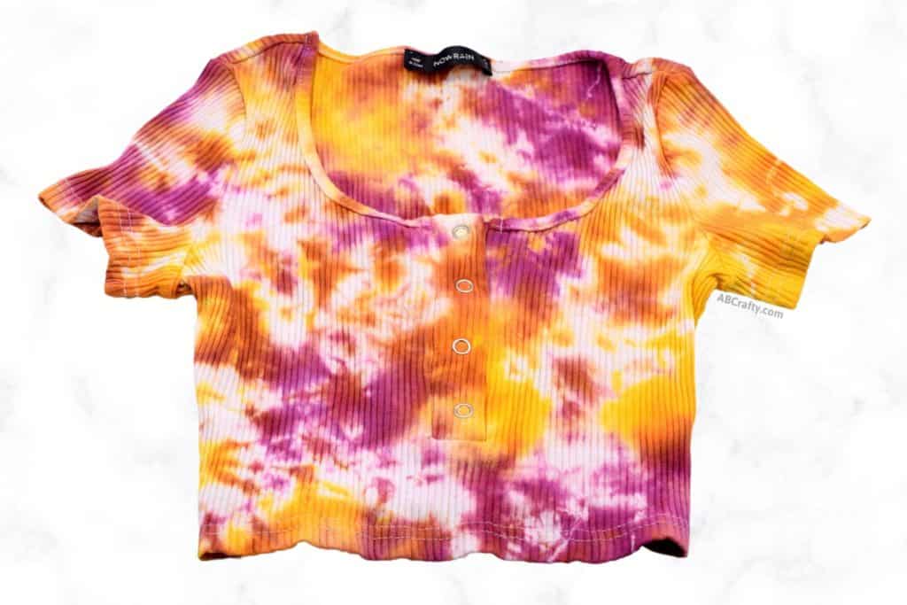 front of the finished tie dye crop top with pink, orange, and yellow designs