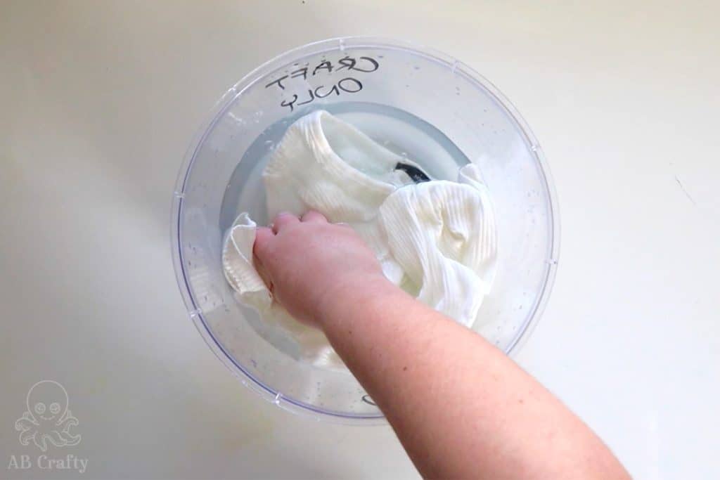 soaking the shirt in a bucket of water