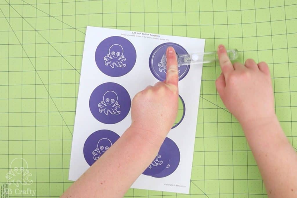 using a circle cutter to cut out the AB crafty logo from a piece of paper on a cutting mat