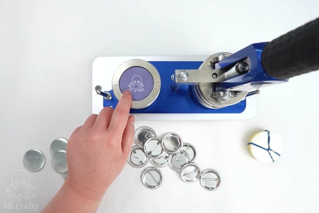 placing the mylar circle on top of the cut out AB Crafty logo in the button making machine