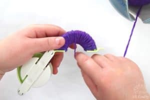 wrapping multiple rounds of purple yarn on one side
