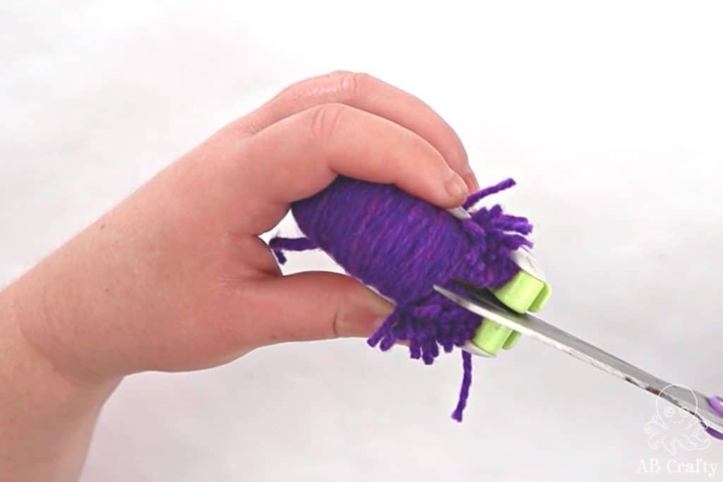 cutting the yarn with scissors down the middle