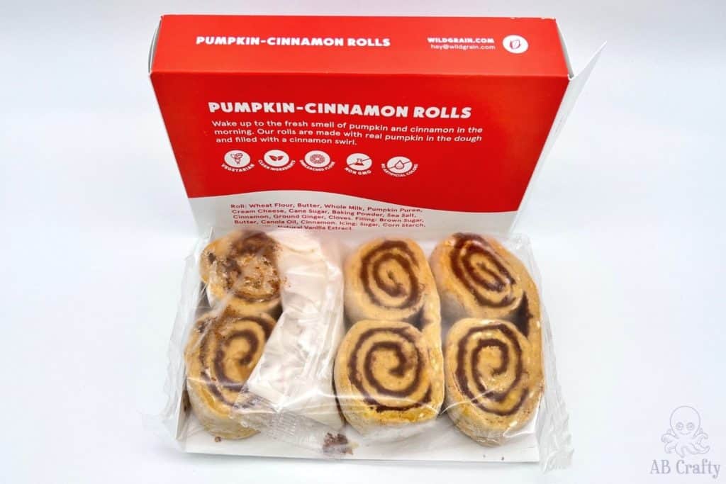 box of wildgrain pumpkin cinnamon rolls with the rolls outside of the box in the packaging