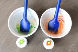 bowls with frosting and orange and green food coloring