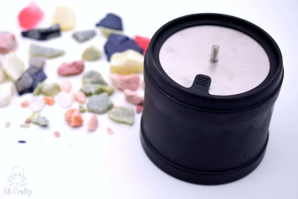 tumbler barrel with a lip on the lid and stones in the background