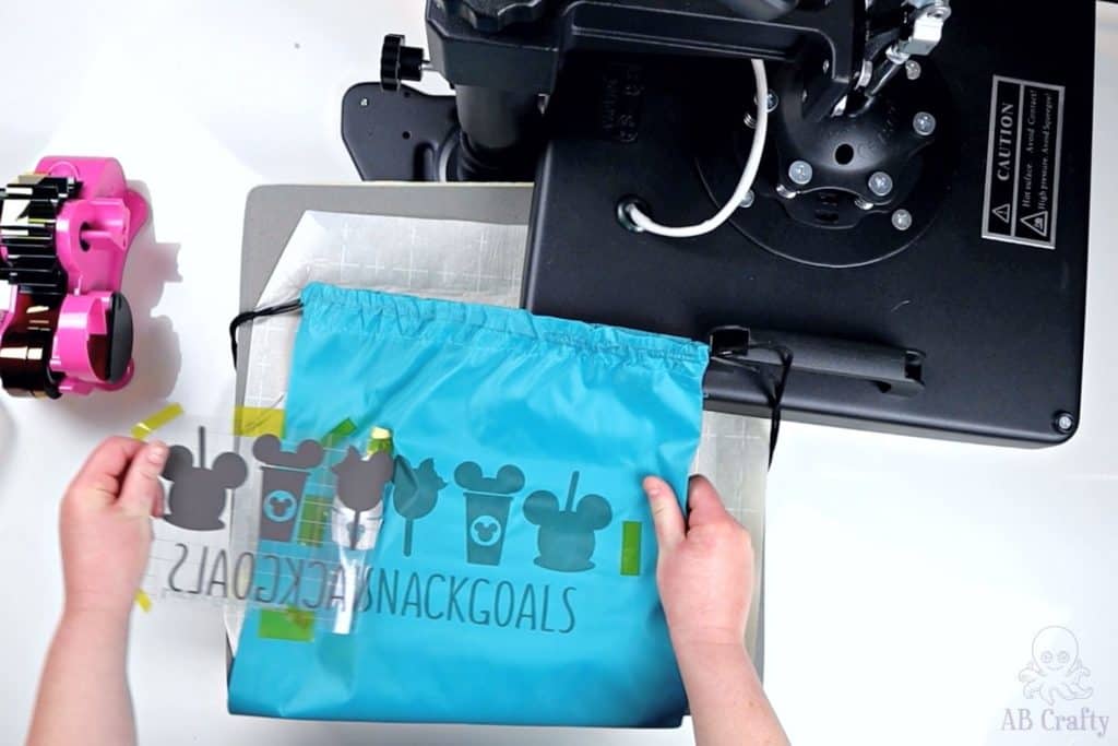 pealing the sublimation design away from the drawstring bag to show the disney snack design on the bag