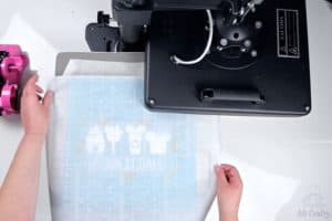 covering the drawstring bag and design with parchment paper on the heat press