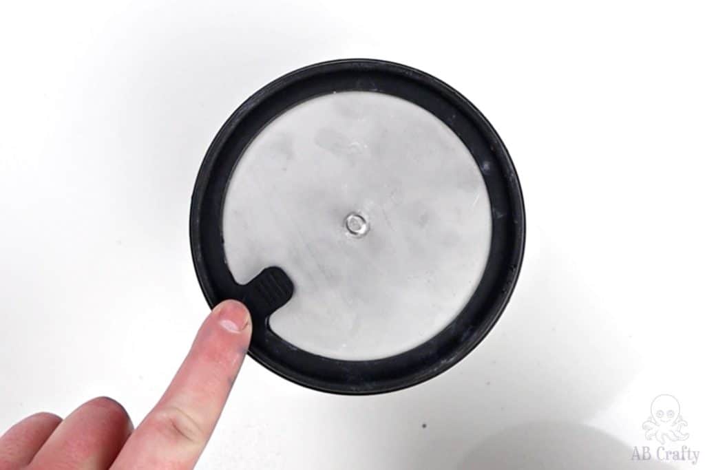 pointing to the pull tab on the inner lid of a barrel