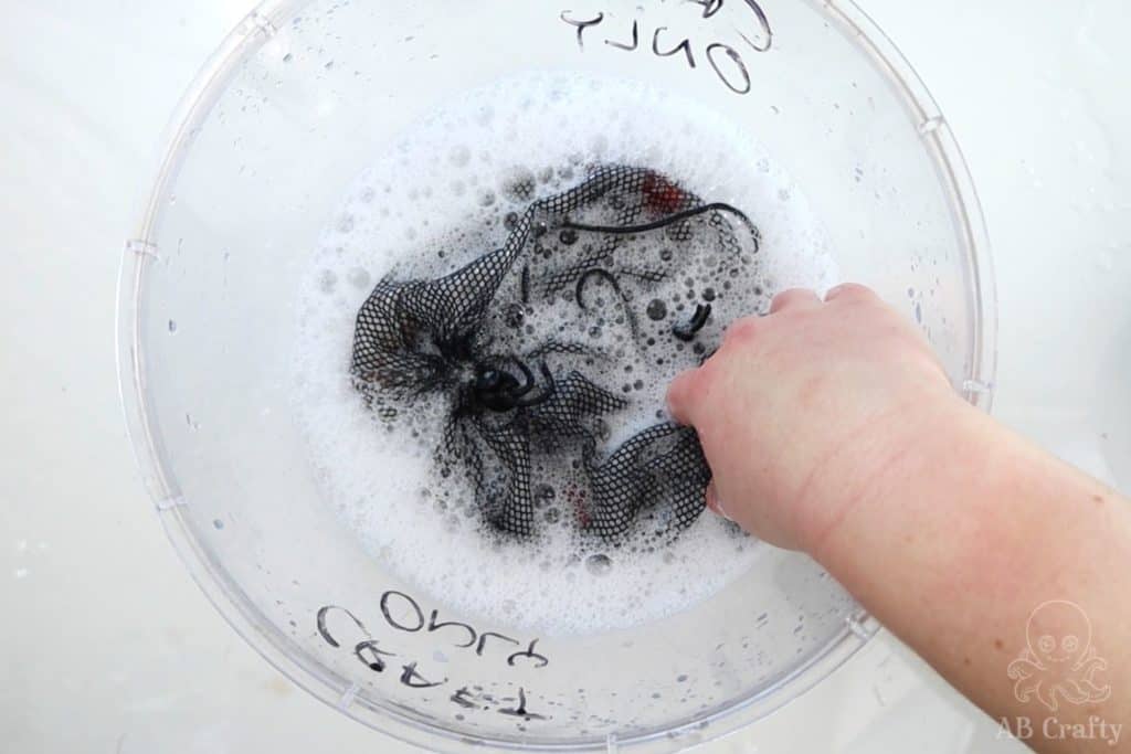 washing the stones in a mesh bag a bin with soap