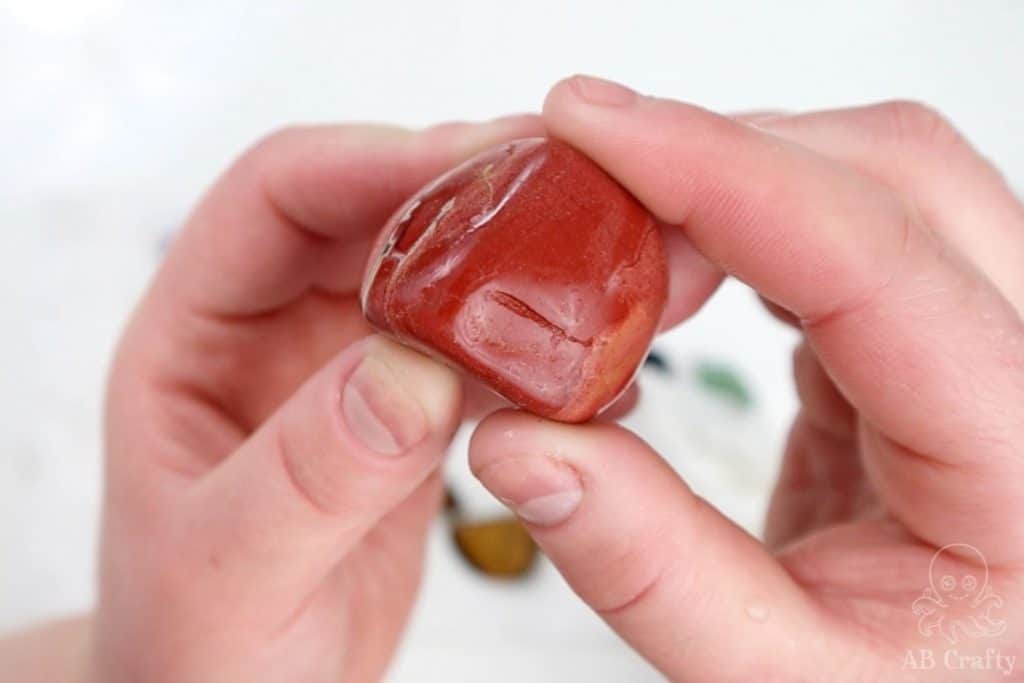 holding a jasper that's been through the first step of polishing, showing the bumps in it