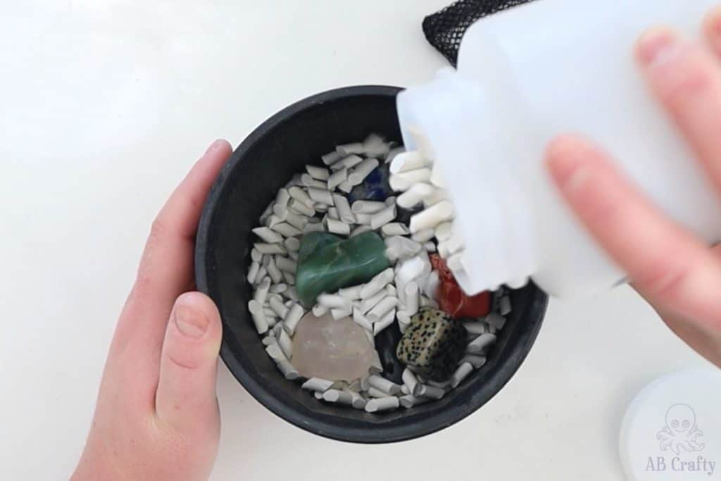 pouring polly plastics ceramic filler into the barrel with stones