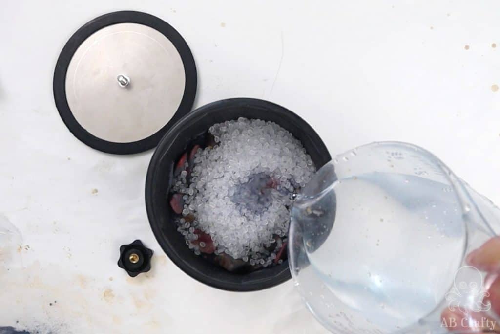 pouring water into the barrel with stones and plastic filler beads