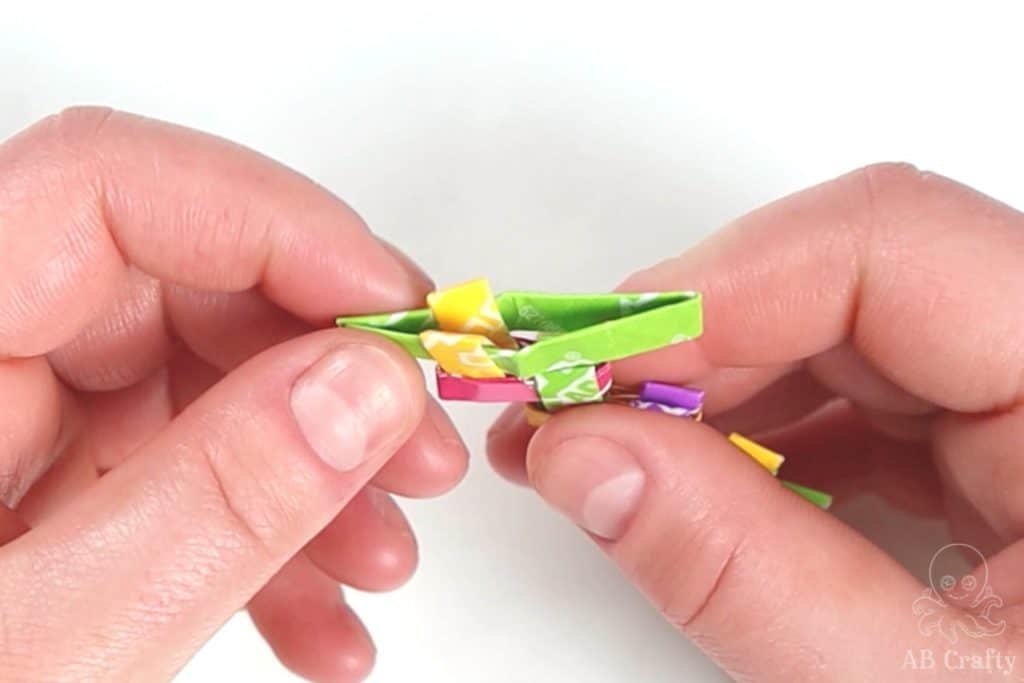 inserting a green candy wrapper into the end of the chain