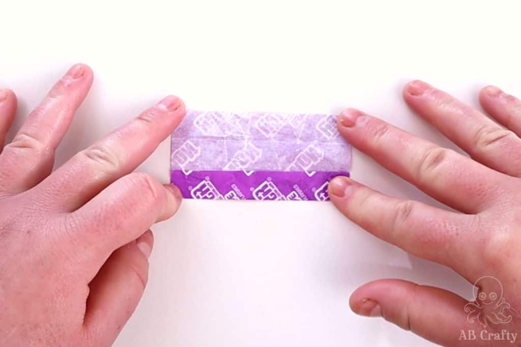 folding the side of a purple candy wrapper
