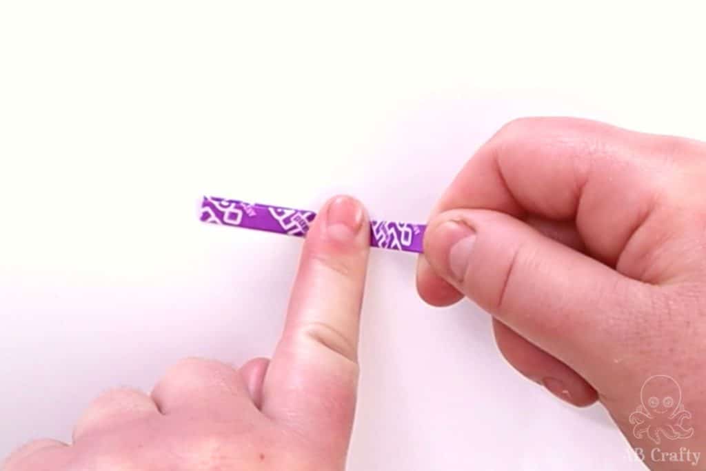 using a finger to hold the middle of a folded wrapper
