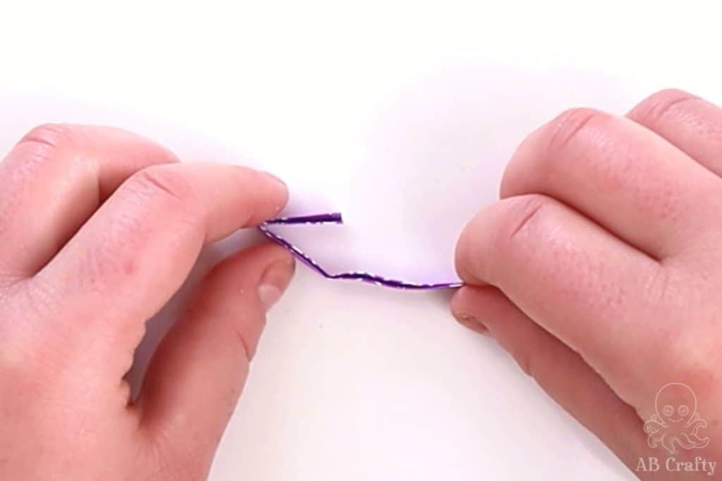 folding the side of a purple candy wrapper to the middle