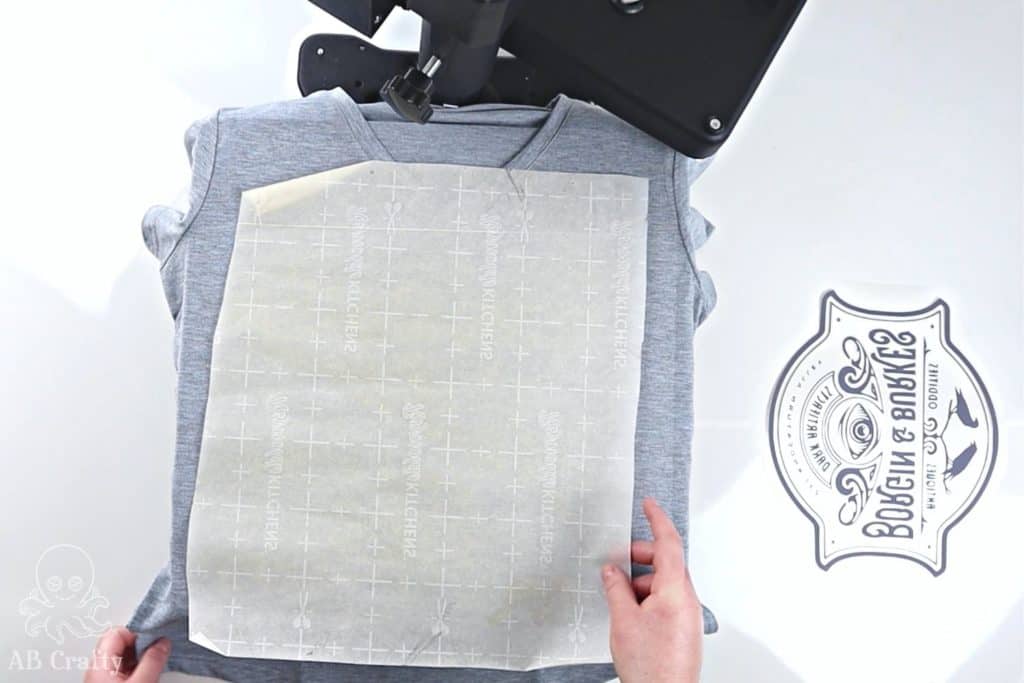 showing parchment paper on top of a cricut infusible ink shirt on top of a heat press