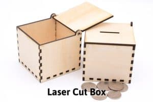 two laser cut boxes, one open and one closed coin box with coins in front of it