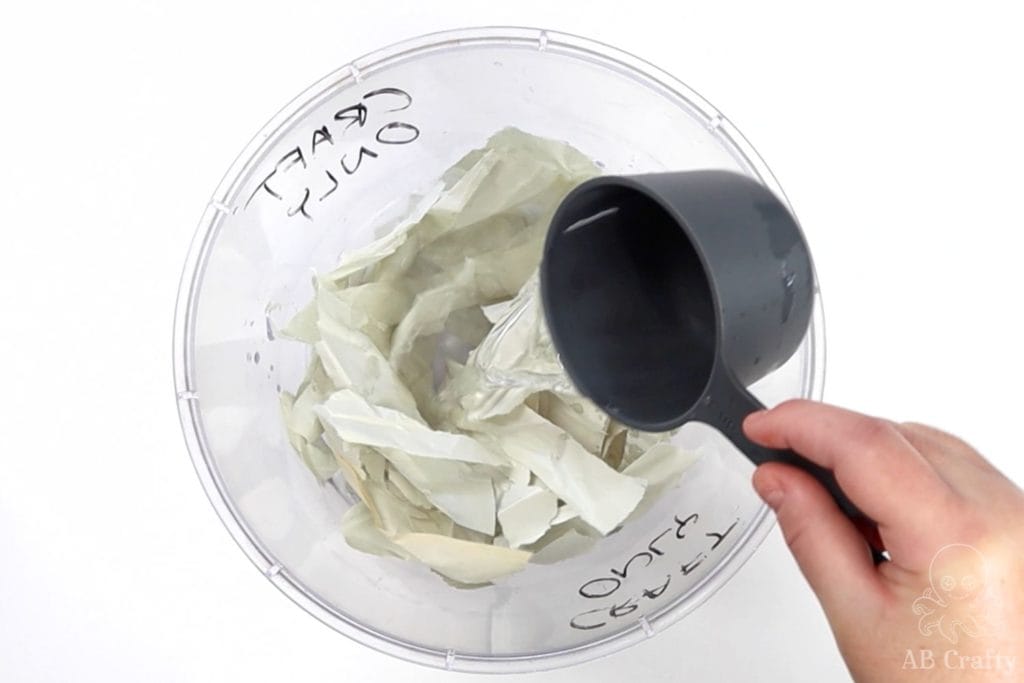 pouring water into bowl with ripped up pieces of paper