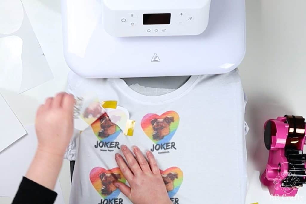 pulling the sublimation paper off of a white shirt to reveal the image