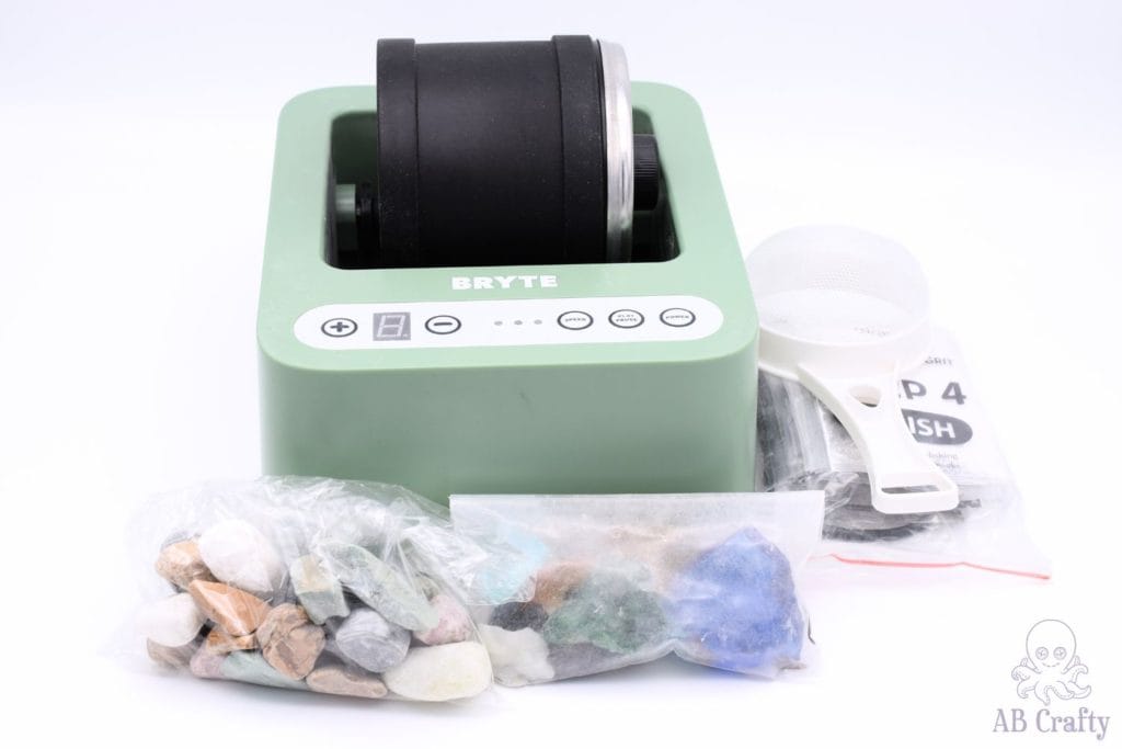 Bryte rock tumbler kit in green with stones and glass and grit.