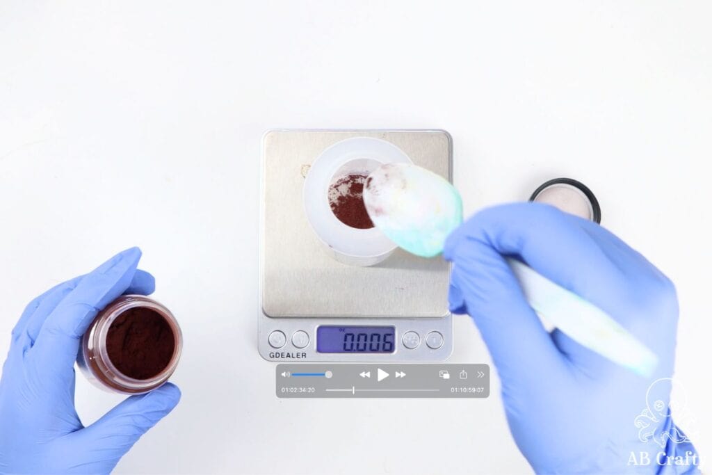 plastic spoon pouring powdered dye into a bottle on a food scale