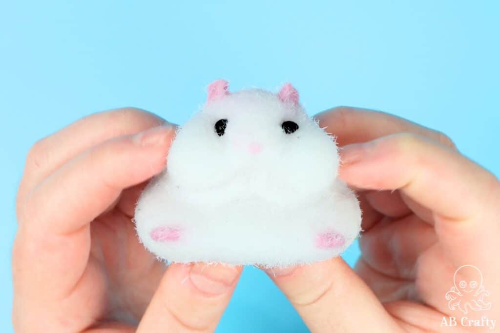 holding a diy taba squishy in the shape of a white hamster