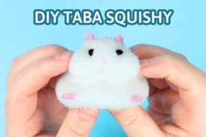 holding a white hamster taba squishy with pink ears and fit and the title saying "diy taba squishy