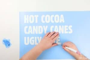 using a weeding tool to weed the letters of the doormat stencil