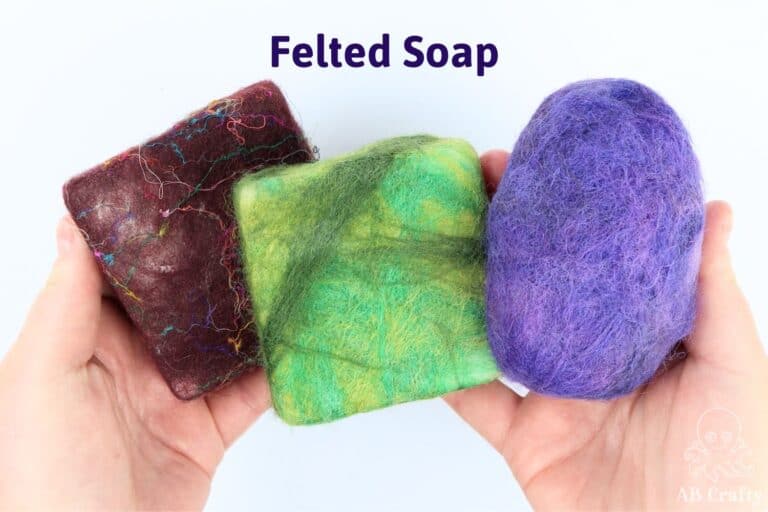 hands holding 3 felted soaps, one red with silk fibers, one different colors of green, and a purple round one, with the title "felted soap"