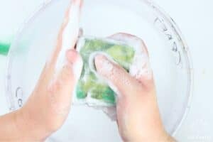 rubbing the side of a bar of soap covered in wool and mesh fabric